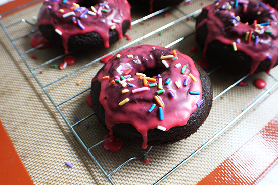 Chocolate baked donuts with pink icing.